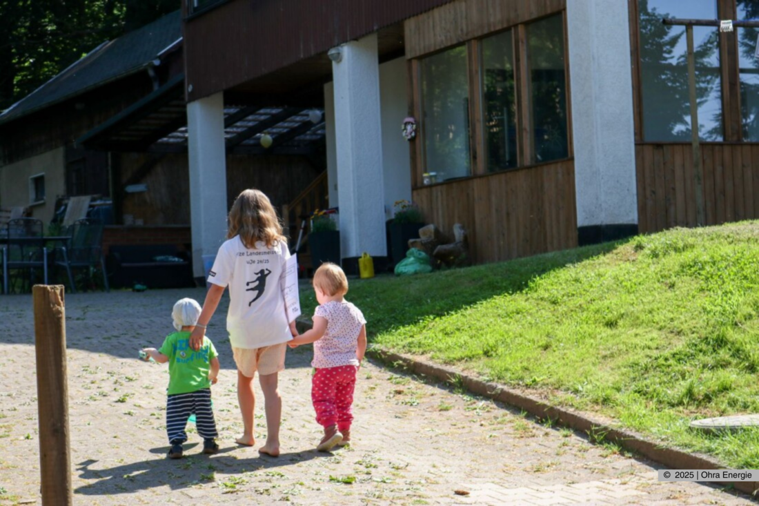 Drei Kinder laufen gemeinsam über das Gelände der Einrichtung.