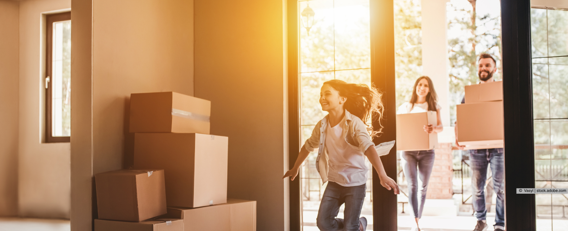 Familie mit Umzugskartons betritt ein Haus 