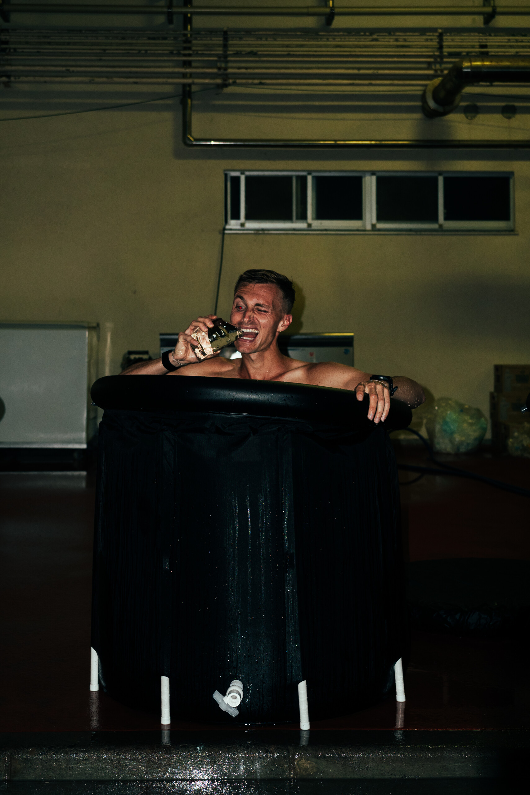 Jonathan Hilbert sitzt in einem Eisbad mit einem großen Stück Eis in der Hand. 