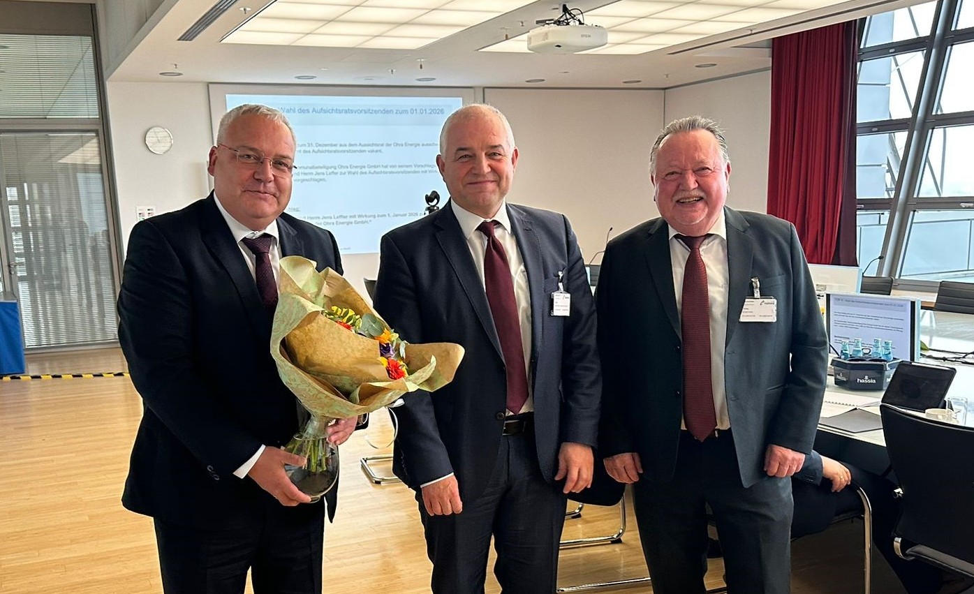 v.l. Michael Fischer (Geschäftsführer Ohra Energie GmbH), Jens Leffler (Bürgermeister Gemeinde Drei Gleichen und neuer Vorsitzender des Aufischtsrates), Klaus Reißig (ehemaliger Vorsitzender des Aufsichtsrates) stehen in einem Besprechungsraum. Herr Fischer überreicht Blumen und alle lächeln in die Kamera. Ohra Energie