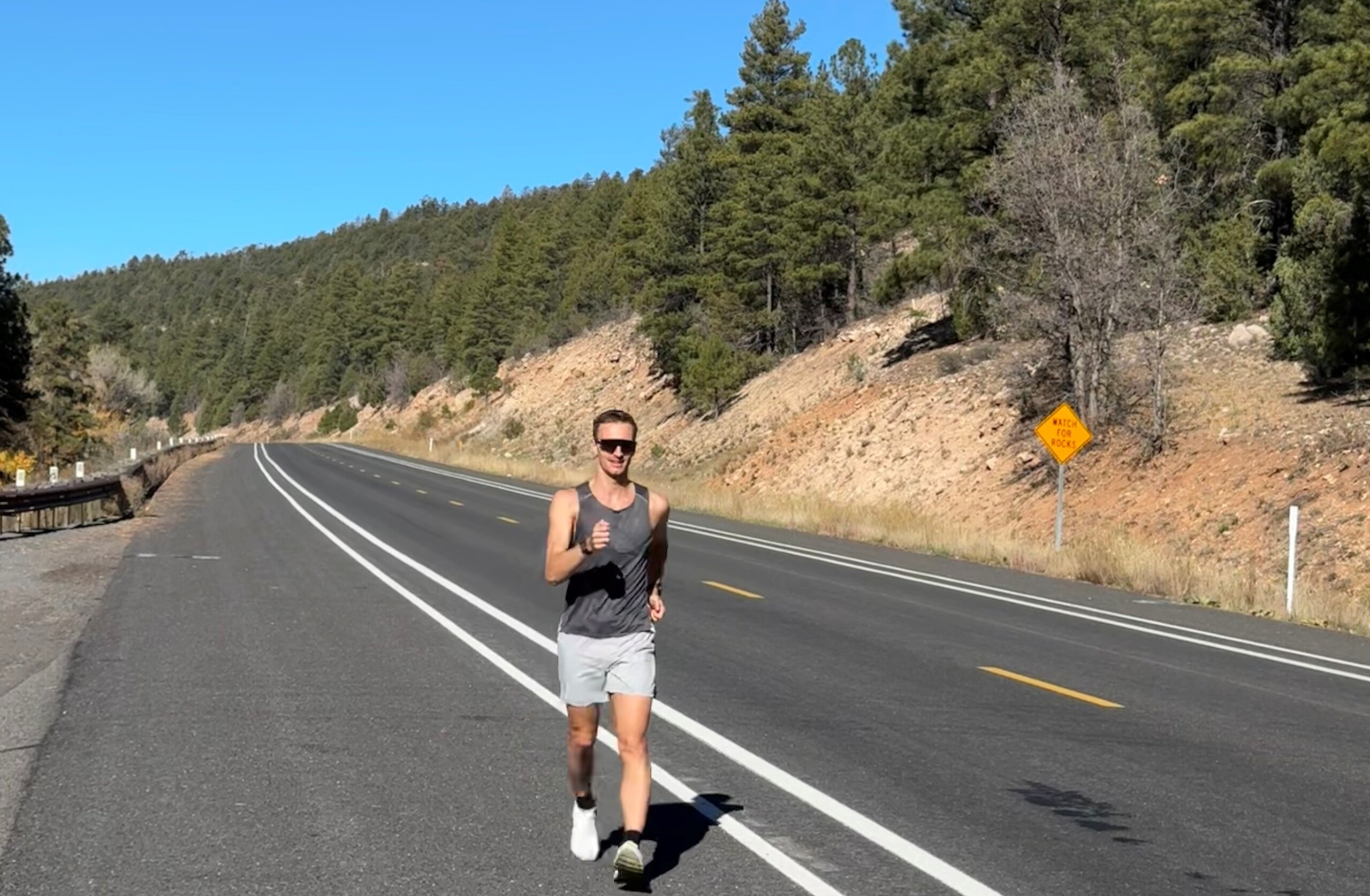 Jonathan Hilbert läuft auf der Straße in Arizona. Dabei ist er von viel Natur umgeben, blauem Himmel und Sonnenschein. 