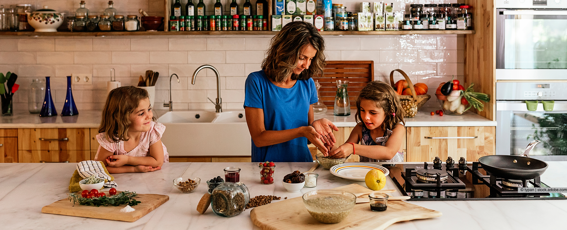 Eine Frau und zwei Kinder kochen in einer Küche 