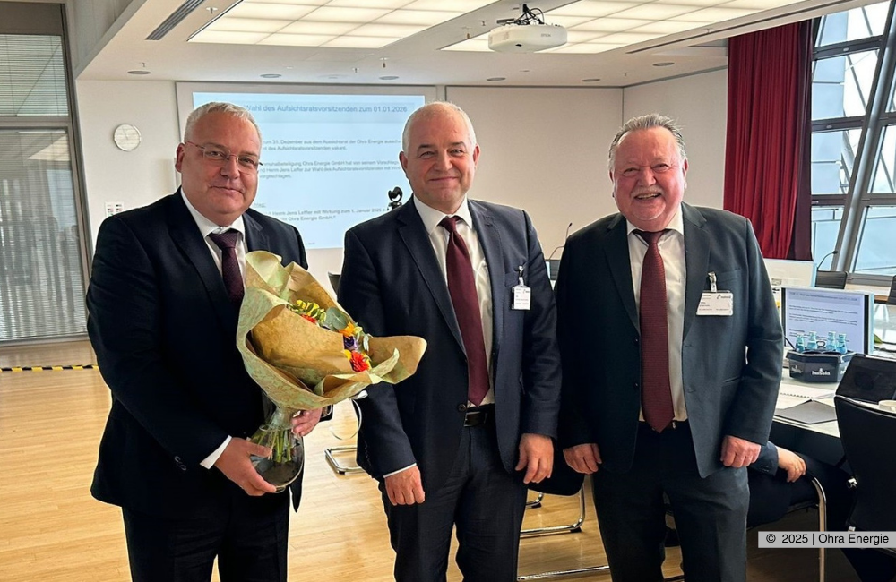 v.l. Michael Fischer (Geschäftsführer Ohra Energie GmbH), Jens Leffler (Bürgermeister Gemeinde Drei Gleichen und neuer Vorsitzender des Aufischtsrates), Klaus Reißig (ehemaliger Vorsitzender des Aufsichtsrates) stehen in einem Besprechungsraum. Herr Fischer überreicht Blumen und alle lächeln in die Kamera. Ohra Energie