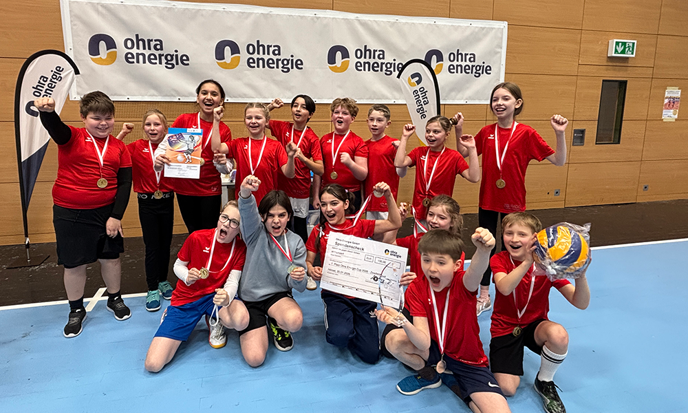 Strahlende Gewinner des Ohra-Energie-Cups: Zahlreiche Kinder mit Medaillen, Volleybällen und zwei symbolischen Schecks.