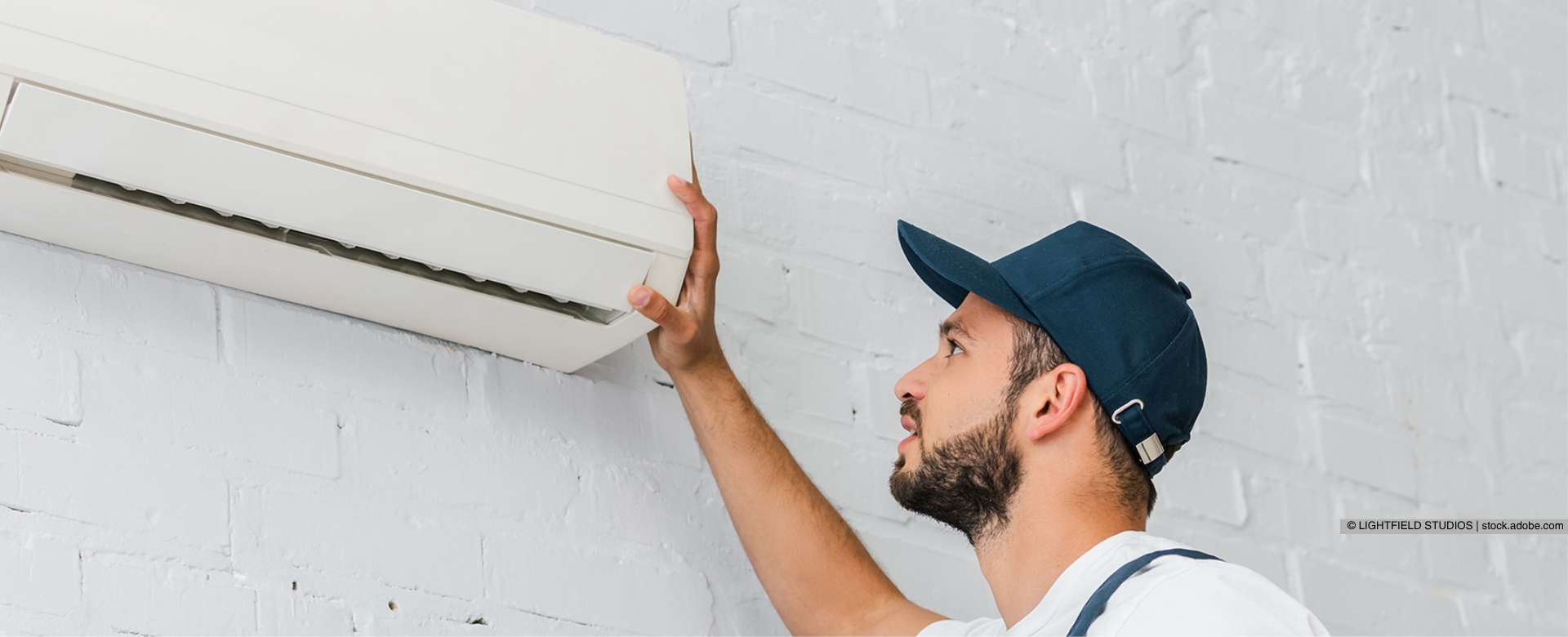 Ein Mann installiert eine Klimaanlage an einer Wand 