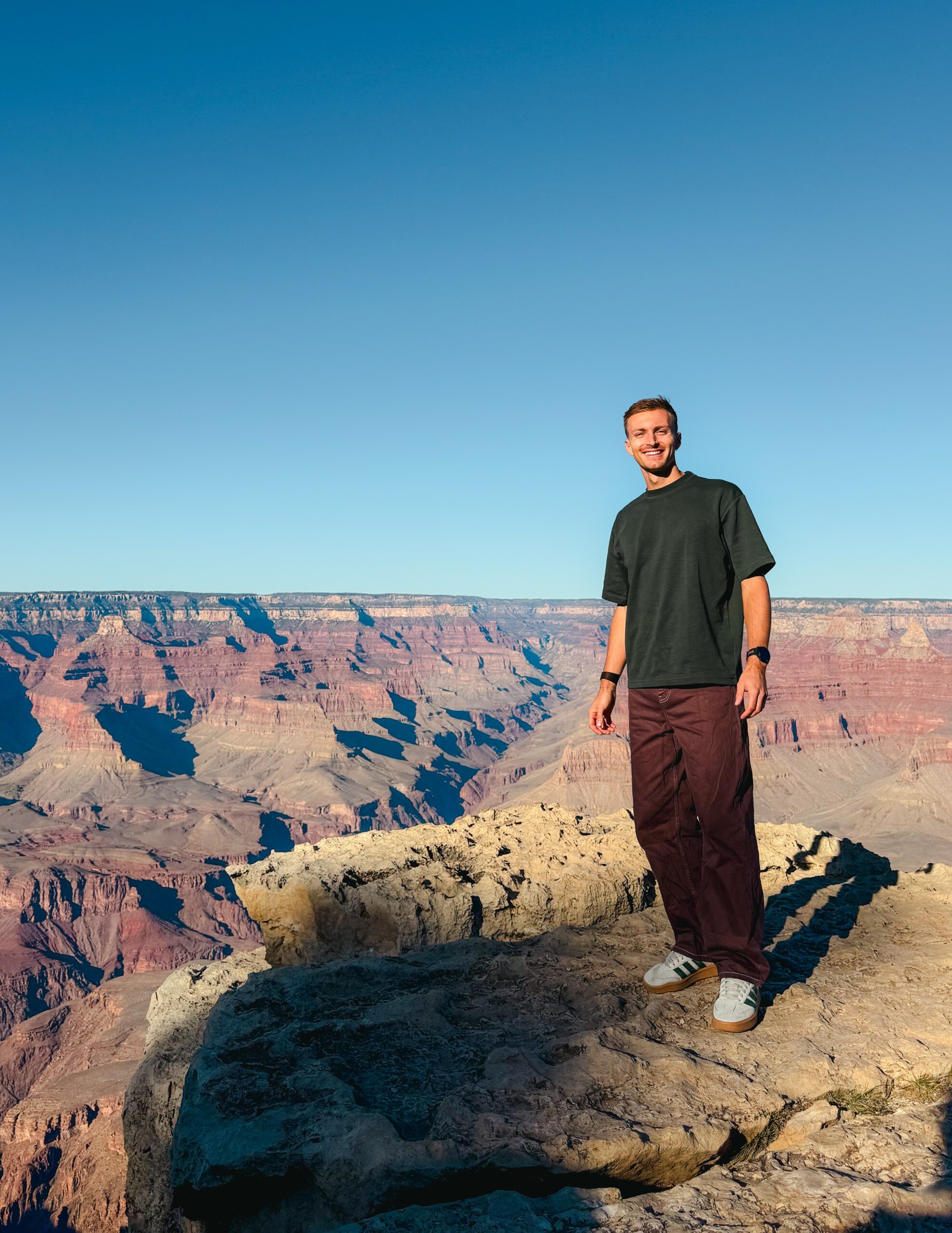 Jonathan Hilbert beim Sightseeing des Grand Canyons. Dabei ist im Hintergrund die Kulisse mit blauem Himmel zu sehen.