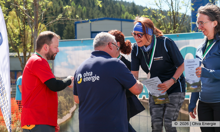 Gewinnerin aus dem OEG-Team wird bei der Siegerehrung geehrt, während der Geschäftsführer gratuliert.