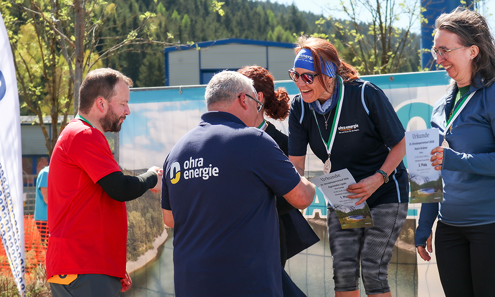 Gewinnerin aus dem OEG-Team wird bei der Siegerehrung geehrt, während der Geschäftsführer gratuliert.