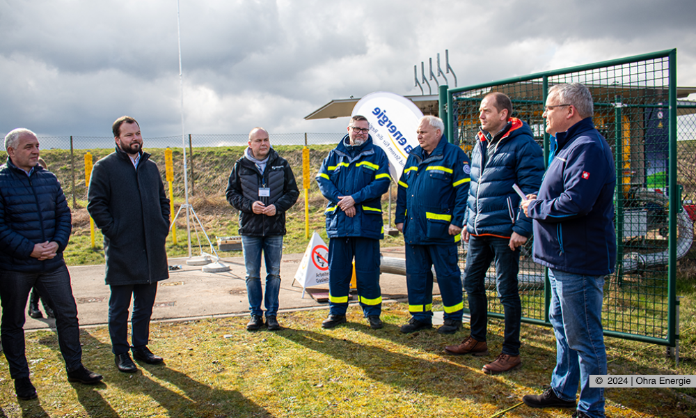 Volkmar Braune (2. v.r.) stellt die mobile Gasdruckregel- und Messanlage vor. (Von links nach rechts: Jens Leffler (Bürgermeister Gemeinde Drei Gleichen), Onno Eckert (Landrat Landkreis Gotha), Mario Stötzer (Leiter Netzbetrieb Ohra Energie GmbH), Udo Hartmann (BsB Ausbildung THW),  M. Heydick (THW), Volkmar Braune (Technischer Leiter Ohra Energie GmbH), Michael Fischer (Geschäftsführer Ohra Energie GmbH).