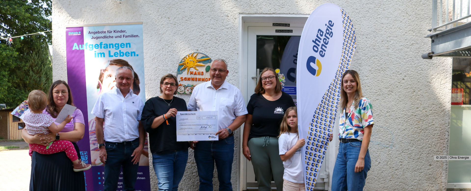 Übergabe des Spendenschecks beim Sonnenhof - alle Beteiligten schauen lächselnd in die Kamera